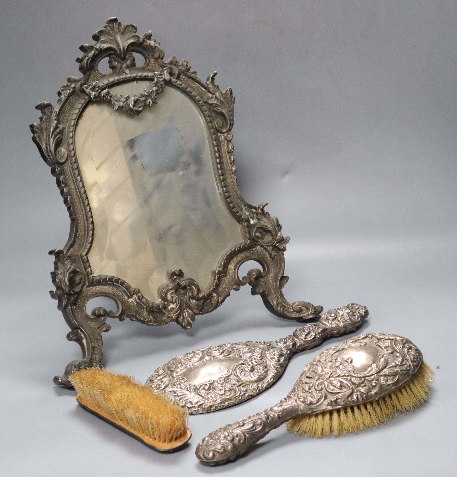 A Victorian cast metal easel mirror and a white metal mounted brush set